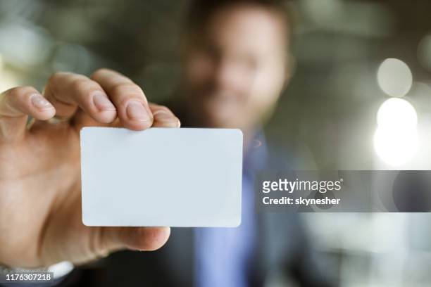nahaufnahme einer leeren visitenkarte in der hand des mannes. - credit card stock-fotos und bilder