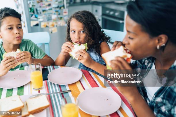 moeder en kinderen eten sandwiches - mother and child snacking stockfoto's en -beelden
