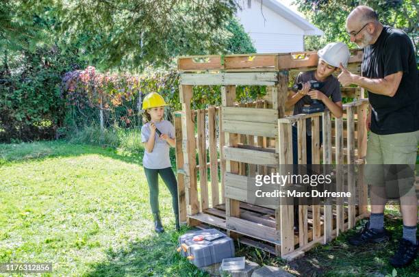 two kids building a wooden shack - hut stock pictures, royalty-free photos & images