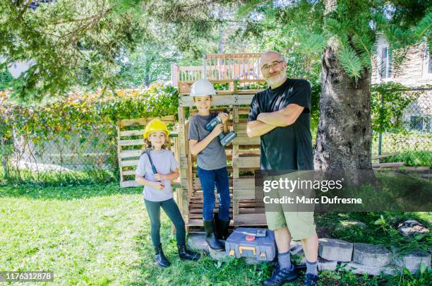 deux gosses fiers de leur cabane en bois - cabane structure bâtie photos et images de collection