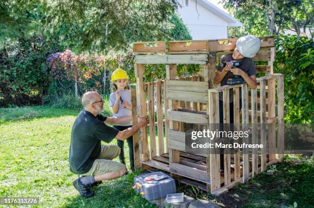 zwei kinder bauen eine holzhütte - transportpalette stock-fotos und bilder