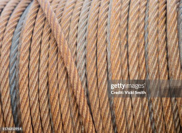 close up of a roll of rustic old wire cables - kabelwinden stock-fotos und bilder