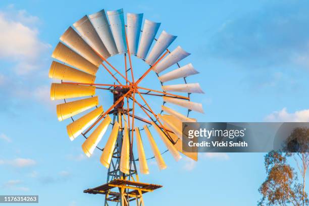 colored windmill out in the country with blue sky and clouds - outback queensland stock pictures, royalty-free photos & images