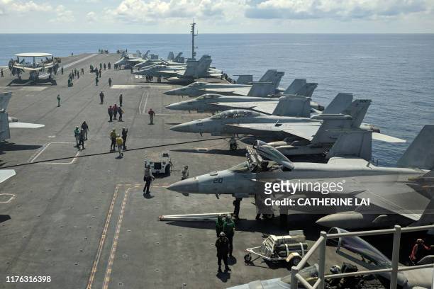 This photograph taken on October 16, 2019 shows US Navy F/A-18 Super Hornets multirole fighters and an EA-18G Growler electronic warfare aircraft on...