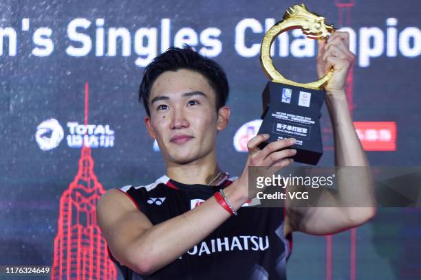 Kento Momota of Japan celebrates with the trophy on the podium after winning the Men's Singles final match against Anthony Sinisuka Ginting of...