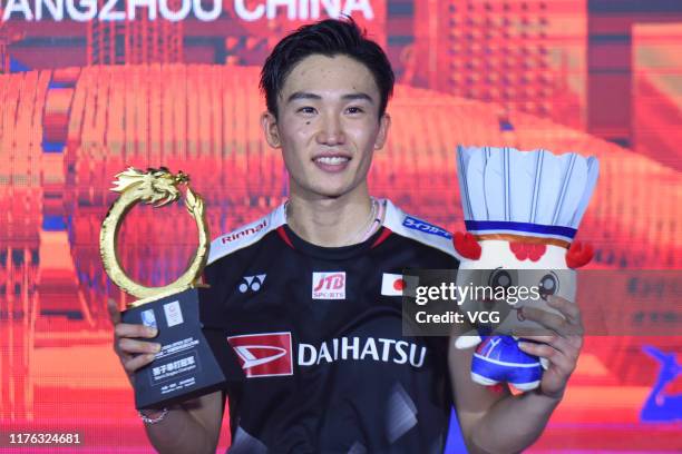 Kento Momota of Japan celebrates with the trophy on the podium after winning the Men's Singles final match against Anthony Sinisuka Ginting of...