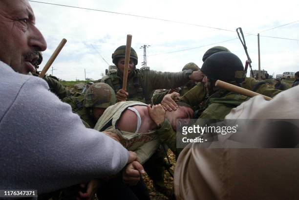 Palestinian demonstrators and Israeli soldiers scuffle during a protest against the construction of Israel's controversial separation barrier in the...