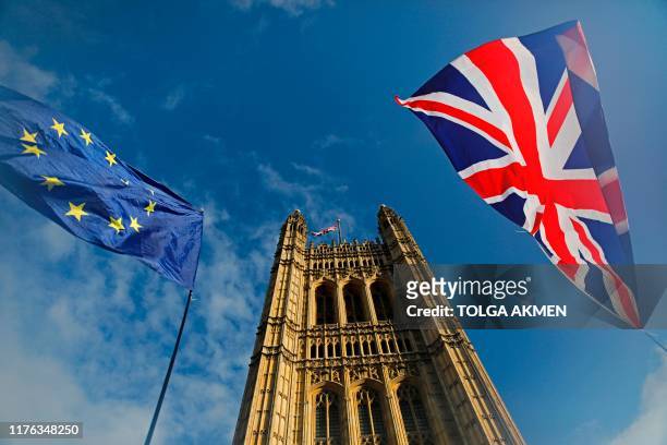 And Union flags flutter in the breeze in front of the Victoria Tower, part of the Palace of Westminster in central London on October 17, 2019. -...