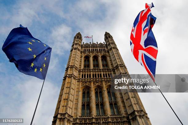 And Union flags flutter in the breeze in front of the Victoria Tower, part of the Palace of Westminster in central London on October 17, 2019. -...