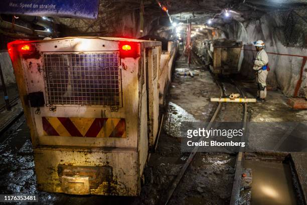 Freight wagons containing mined platinum rich rock stand on tracks in the mine shaft ready for transport to the surface during a media tour of the...