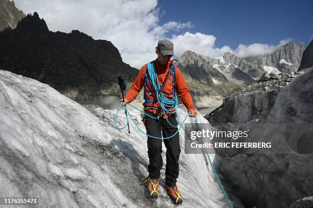 Pierre Sauget, a mountain guide and a CRS lifeguard-rescuer of Briancon passes a crevasse at the Mer de Glace at the Mont Blanc mountain range, in...