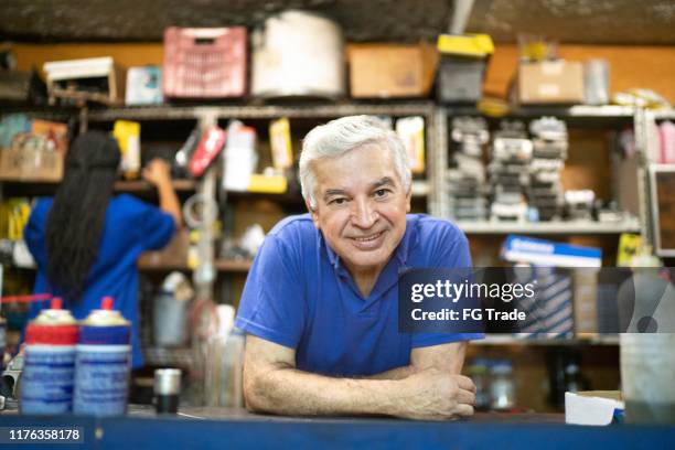 mecânico sênior que behing um contador que trabalha em uma auto loja de reparo - small - fotografias e filmes do acervo