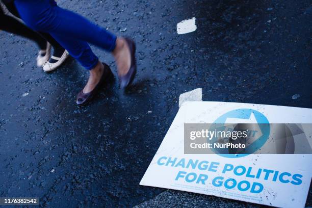 People walk past a placard for the Brexit Party lying in the road on Abingdon Street outside the Houses of Parliament in London, England, on October...