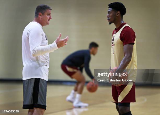 Boston College men's basketball head coach Jim Christian, left, talks to player Jared Hamilton, right, during a practice session in the Power Gym...