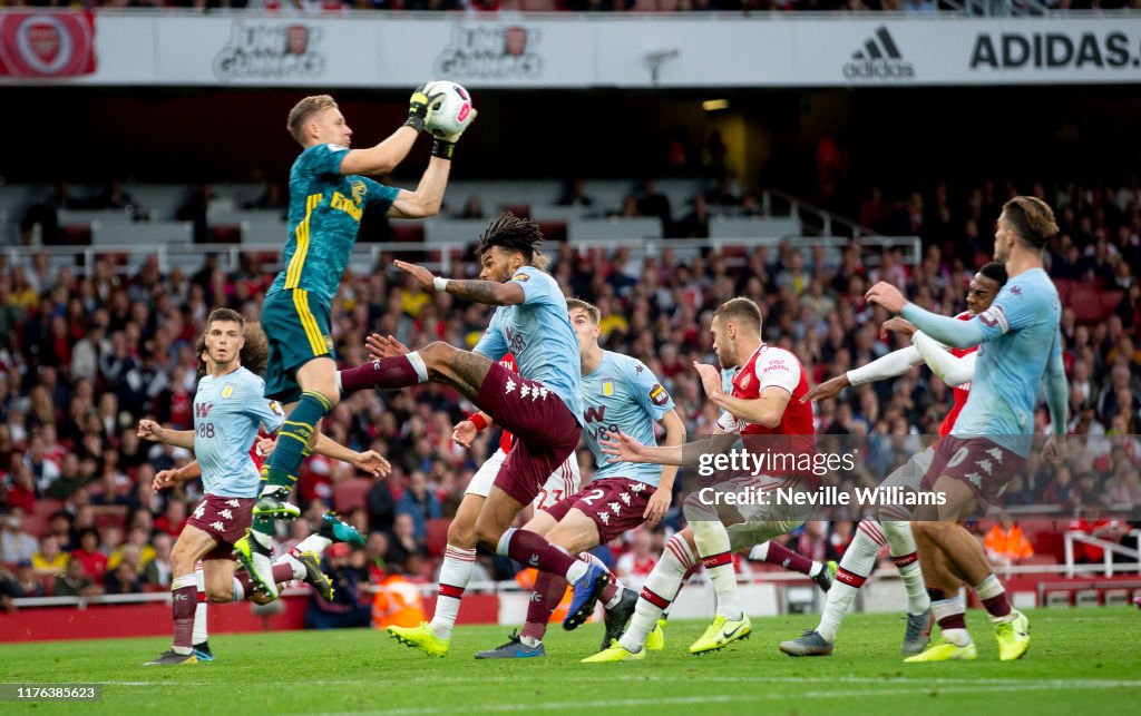 Tyrone Mings of Aston Villa is challenged by Bernd Leno of Arsenal ...