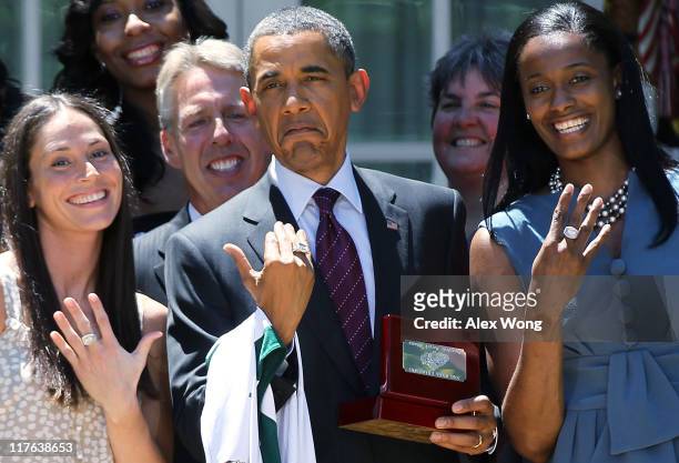 President Barack Obama shows off a champion ring which he receives as a gift with Seattle Storm’s forward guard Sue Bird Coach Brian Agler and Swin...