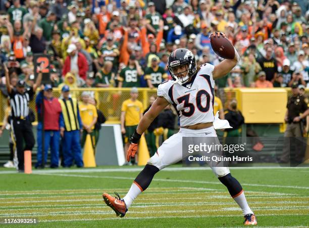 Phillip Lindsay of the Denver Broncos reacts after scoring a touchdown in the first quarter against the Green Bay Packers at Lambeau Field on...