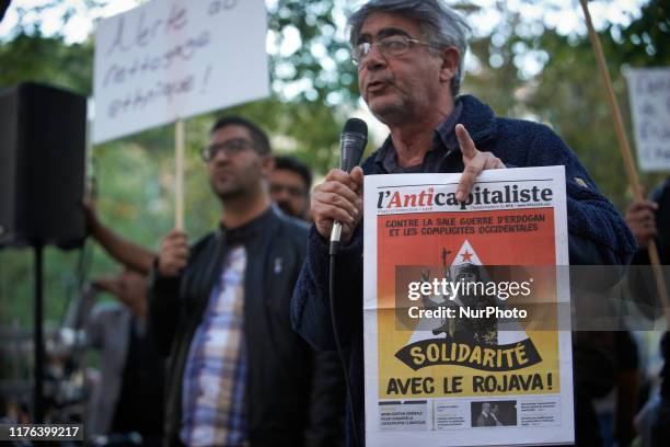 Man speaks with a microphone while holding a newspaper reading 'Solidarity with Rojava'. As Turkey attacked Kurdish militia positions in northeast...