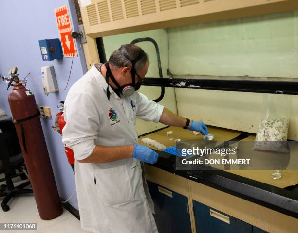 Drug Enforcement Administration chemist checks confiscated powder containing fentanyl at the DEA Northeast Regional Laboratory on October 8, 2019 in...
