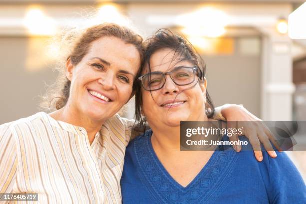 mature lesbian multi ethnic couple posing at their home front door - fat lesbian stock pictures, royalty-free photos & images