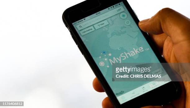 Person checks the "MyShake" app on their smartphone in Hollywood on October 17, 2019. - California on Thursday launched the country's first...