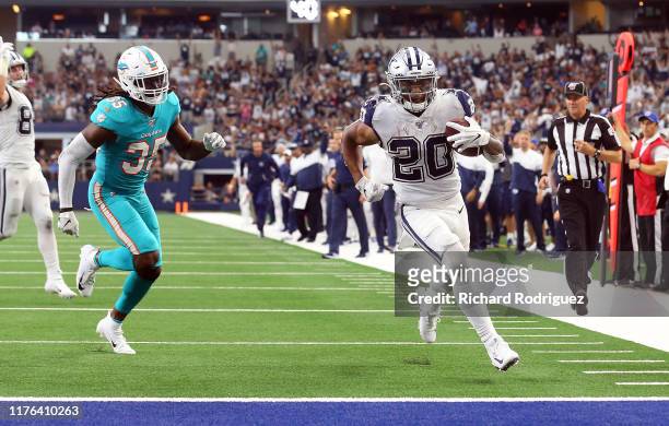Walt Aikens of the Miami Dolphins chases Tony Pollard of the Dallas Cowboys as he run the ball in for a touchdown in the fourth quarter at AT&T...
