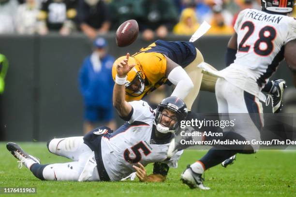 Preston Smith of the Green Bay Packers pressures Joe Flacco of the Denver Broncos to the ground as he attempts to throw to Royce Freeman during the...