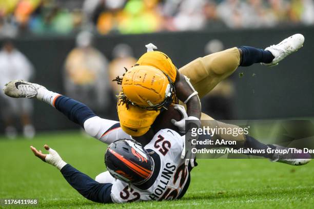 Justin Hollins of the Denver Broncos tackles Jamaal Williams of the Green Bay Packers during the second half of the Packers' 27-16 win on Sunday,...