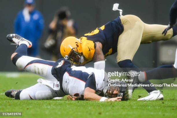 Preston Smith of the Green Bay Packers pressures Joe Flacco of the Denver Broncos to the ground as he attempts to throw to Royce Freeman during the...
