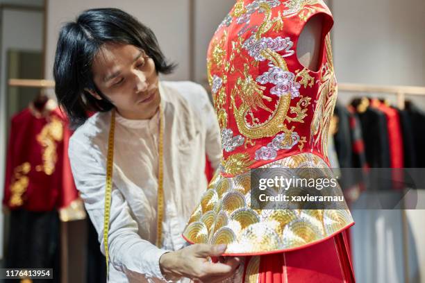 male qun gua designer examining peplum on dressmaker’s model - dressmaker's pattern stock pictures, royalty-free photos & images