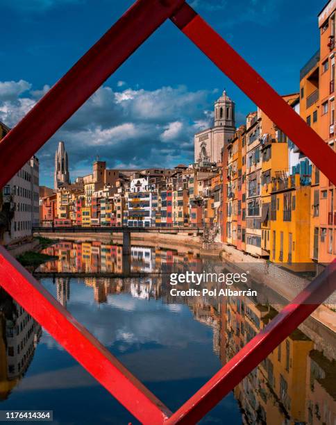 colorful yellow and orange houses and eiffel bridge, old fish stalls, reflected in water river onyar, in girona, catalonia, spain. saint mary cathedral at background. - gerona city fotografías e imágenes de stock