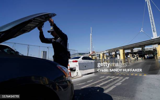 Customs and Border Protection agent checks an automobile for contraband in the line to enter the United States at the San Ysidro Port of Entry on...