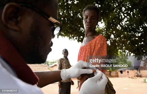 Health worker draws blood from a woman as she takes part in an Human African Trypanosomiasis, also known as sleeping sickness, screening in the...