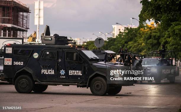 Graphic content / Mexican police patrol in a street of Culiacan, state of Sinaloa, Mexico, on October 17 after heavily armed gunmen in four-by-four...