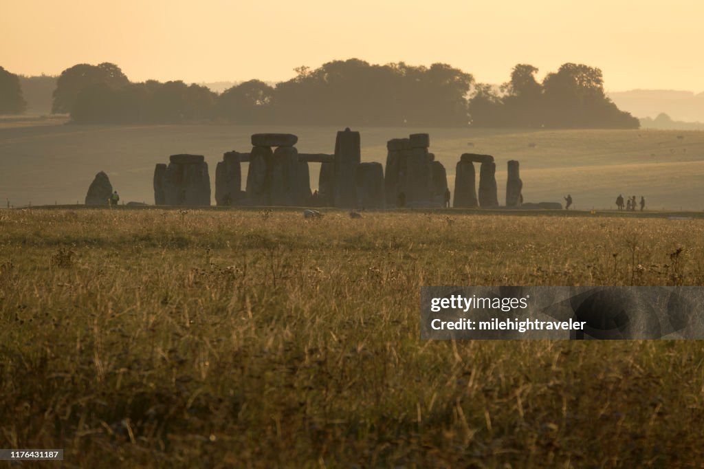 Early morning visitors explore Stonehenge monument Salisbury Plain Wiltshire England