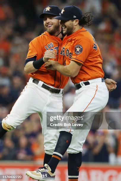 Jake Marisnick of the Houston Astros and Josh Reddick celebrate after winning the American League West Division after defeating the Los Angeles...