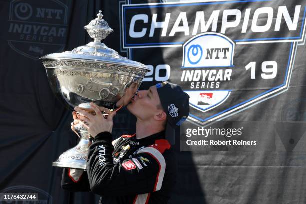 Josef Newgarden of United States and Hitachi Team Penske Chevrolet kisses the Astor Cup after winning the NTT IndyCar Series championship following...