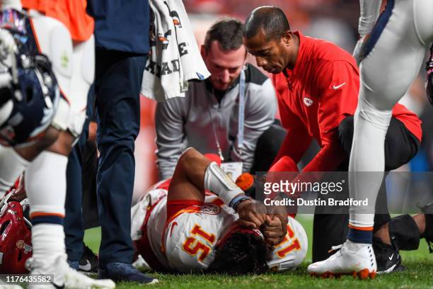 Patrick Mahomes of the Kansas City Chiefs is tended to by trainers after sustaining an injury in the second quarter of a game against the Denver...