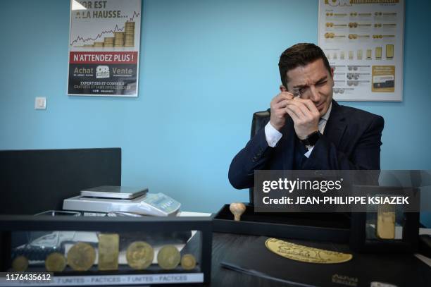 Grocer and founder of "Or en Cash" company Christophe Gerber examines jewellery, on October 9, 2019 at his company's headquarters in La Verpilliere,...