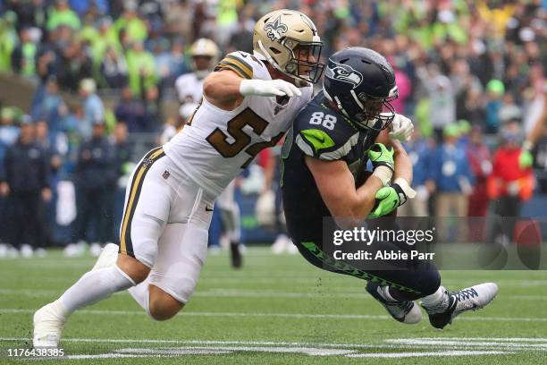 Will Dissly of the Seattle Seahawks completes a pass against Kiko Alonso of the New Orleans Saints in the third quarter during their game at...