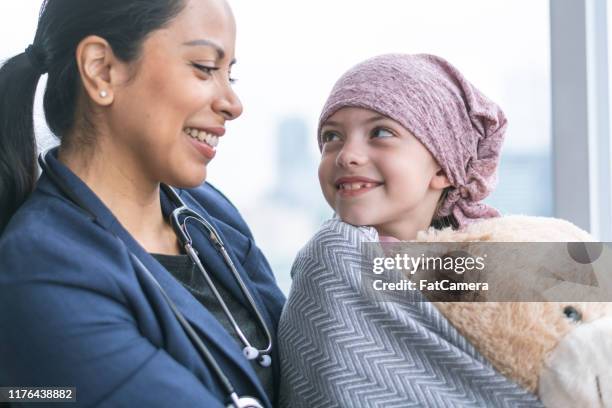 kind doctor comforts young girl with cancer - kind doctor stock pictures, royalty-free photos & images