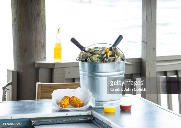 bucket of fresh oysters, corn on the cob, beverage, waterfront - myrtle beach foto e immagini stock