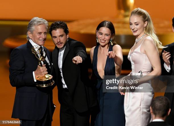 Michael Douglas presents the Outstanding Drama Series award for 'Game of Thrones' to Kit Harington, Emilia Clarke, and Sophie Turner onstage during...