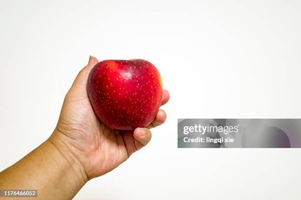 he had a red apple in his hand. - hand holding an apple stock pictures, royalty-free photos & images