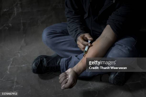 a man who is addicted to drugs is injected into his own blood vessel - heroin addict arm stock pictures, royalty-free photos & images