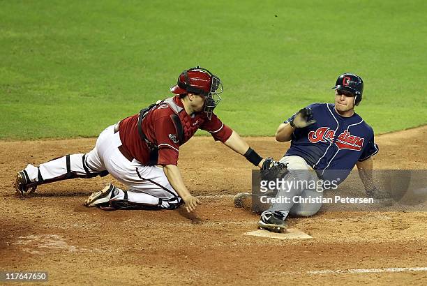 Lou Marson of the Cleveland Indians safely slides in to score a run past the tag from catcher Miguel Montero of the Arizona Diamondbacks during the...