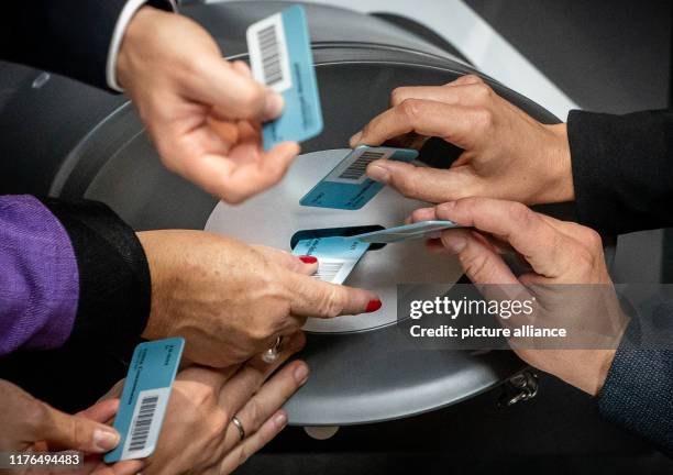 October 2019, Berlin: Members of the Bundestag throw their blue "yes" voting cards into the ballot boxes during the roll-call vote on the property...