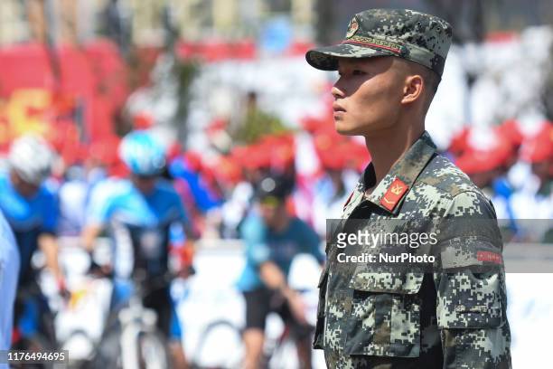 Members of the Chinese Armed Forces assure the security at the finish line of the second stage, 152.3km Beihai-Qinzhou stage, of the 3rd edition of...