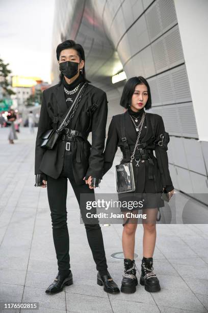 Guests wearing black outfit and Naked Wolf boots are seen during the Seoul Fashion Week 2020 S/S at Dongdaemun Design Plaza on October 18, 2019 in...