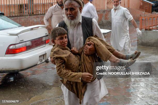 Volunteer carries an injured youth to hospital, following a bomb blast in Haska Mina district of Nangarhar Province on October 18, 2019. At least 28...